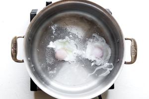 2 eggs poaching in simmering water in a pot