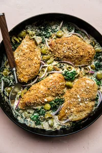 chicken breast with creamed kale topped with Castelvetrano  olives and toasted panko breadcrumbs in a skillet