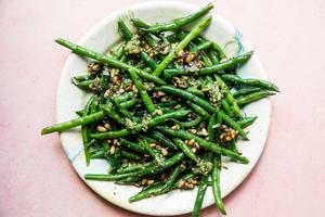 pesto green beans with pine nuts on a plate
