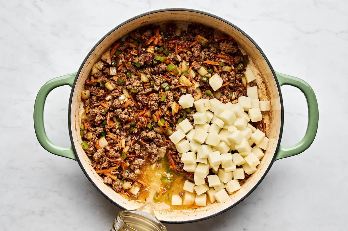 a pan of picadillo made with ground beef, onion, bell pepper, carrots, and spices