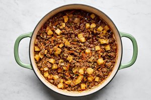 a pan of picadillo made with ground beef, onion, bell pepper, carrots, and spices