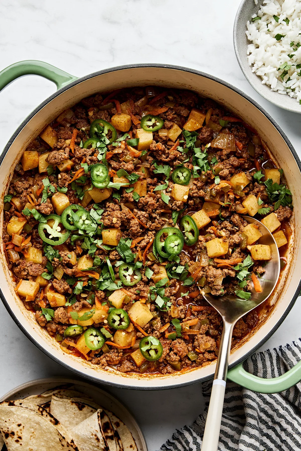 picadillo topped with fresh cilantro and jalapeños, served with rice and a warm tortillas on the side
