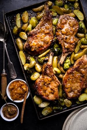 4 seared pork chops on a sheet pan with apricot jam, mustard and butter with Brussels sprouts and fingerling potatoes
