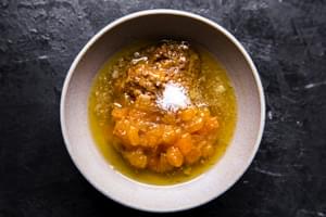 a bowl with apricot jam, melted butter, whole grain mustard, apple cider vinegar and salt