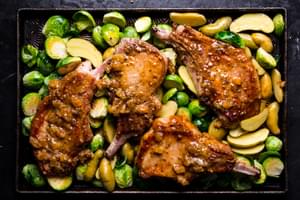 4 seared pork chops on a sheet pan with apricot jam, mustard and butter with Brussels sprouts and fingerling potatoes
