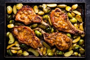 Pork chop sheet pan dinner with apricot jam, mustard and butter roasted with Brussels sprouts and fingerling potatoes