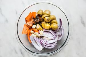 chopped potatoes, carrots, apples and red onion in a glass bowl on the counter