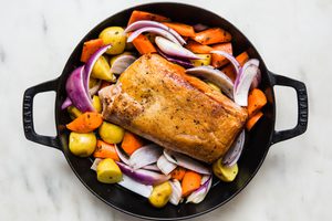 pork loin roast and roasted apples, carrots and potatoes in a dutch oven