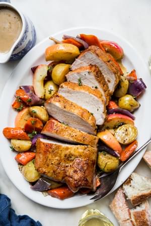 Pork Loin Roast with carrots, potatoes and roasted apples, finished with a cider gravy on a serving platter