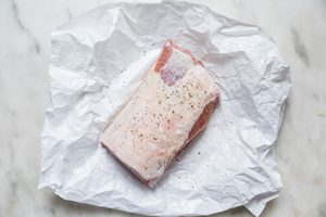 seasoned raw pork loin on a piece of parchment paper