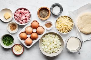 onion, eggs, garlic, cream, brown sugar, salt, pepper, nutmeg, Gruyère, ham and chives in prep bowls