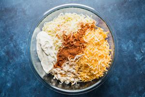 shredded chicken, cheese, sour cream and taco seasoning in a bowl for red enchilada filling