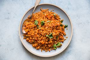 Mexican stye rice shown on a plate with a large spoon