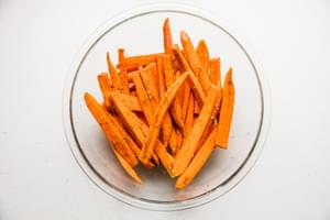 raw carrots tossed with salt, olive oil and za’atar in a glass bowl
