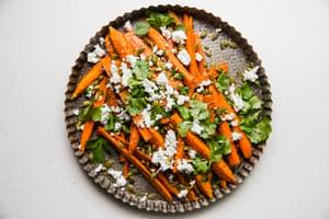 Za’atar Roasted Carrots with Feta and Pumpkin Seeds on a serving plate topped with cilantro