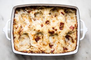 baked potato rösti mixture in a baking dish with indents made by a spoon