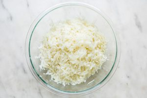 cooked, grated potatoes in a glass bowl