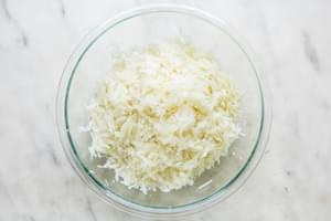 cooked, grated potatoes in a glass bowl
