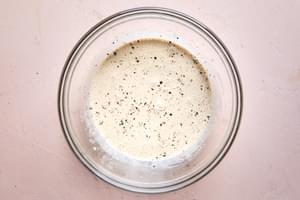 dressing in a bowl made with mayonnaise, ponzu, sugar, pepper, sesame seeds, sesame oil, ginger, and corn starch