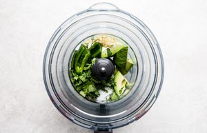 avocado, garlic, sour cream, salt, lime juice, cilantro, and jalapeño to a food processor to make avocado crema