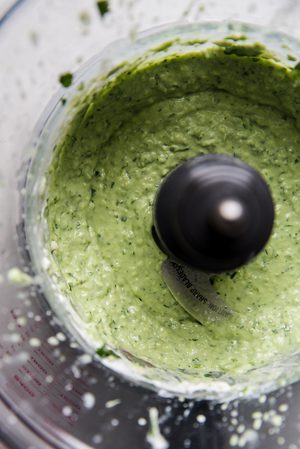 smooth avocado crema in a food processor made with jalapeno, sour cream, cilantro and lime juice