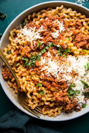 homemade simple ragù in a bowl topped with parmesan cheese