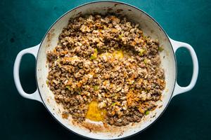 chopped carrots, celery, onions and ground beef being sautéed in olive oil in a pot