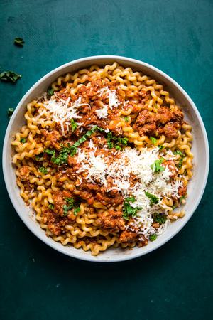 homemade simple ragù in a bowl topped with parmesan cheese