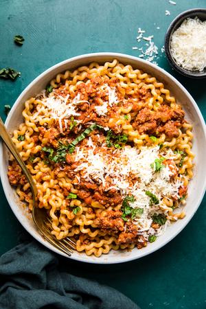 homemade simple ragù in a bowl topped with parmesan cheese
