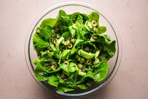 Simple Salad with Shallot Vinaigrette, green olives, pistachios, honey, lemon juice and chives in a bowl