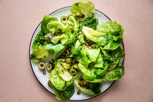 Simple Salad with Shallot Vinaigrette, green olives, pistachios, honey, lemon juice and chives on a plate