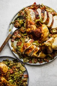 spatchcocked roast chicken on top of shredded Brussels sprouts on a serving platter