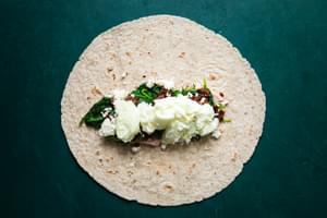 whole wheat tortilla with tomato cream cheese, cooked spinach, feta, sun dried tomatoes and scrambled egg whites