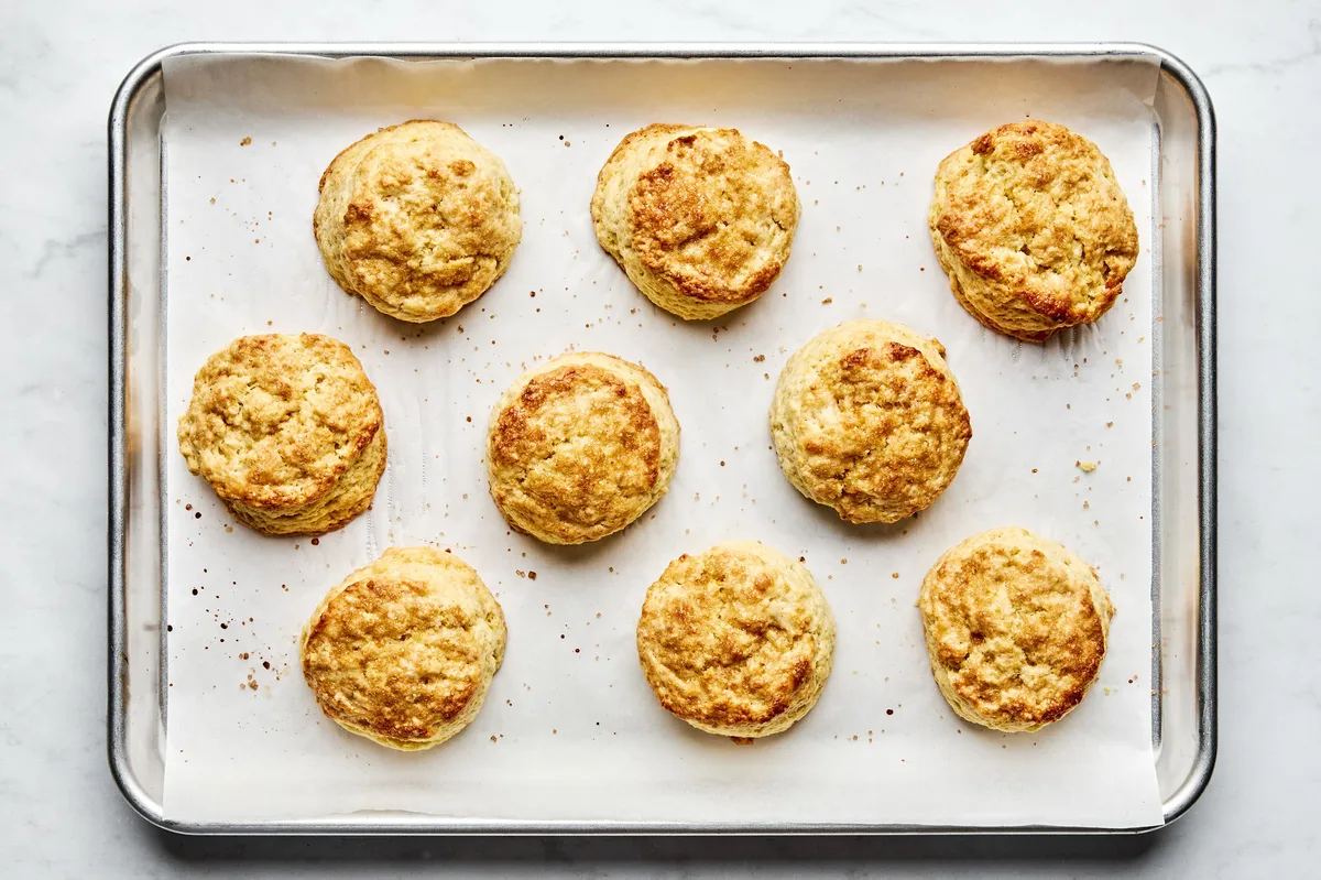 Homemade shortcake biscuits freshly baked on a parchment-lined baking sheet, golden brown with slightly crisp edges