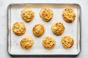 Homemade shortcake biscuits freshly baked on a parchment-lined baking sheet, golden brown with slightly crisp edges