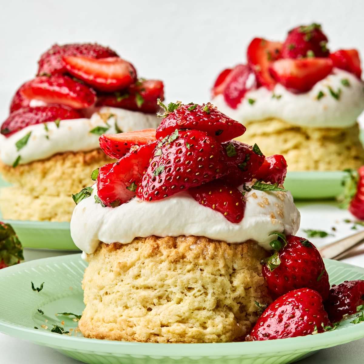 Homemade strawberry shortcake topped with fresh sliced strawberries and fluffy whipped cream, served on a flaky biscuit