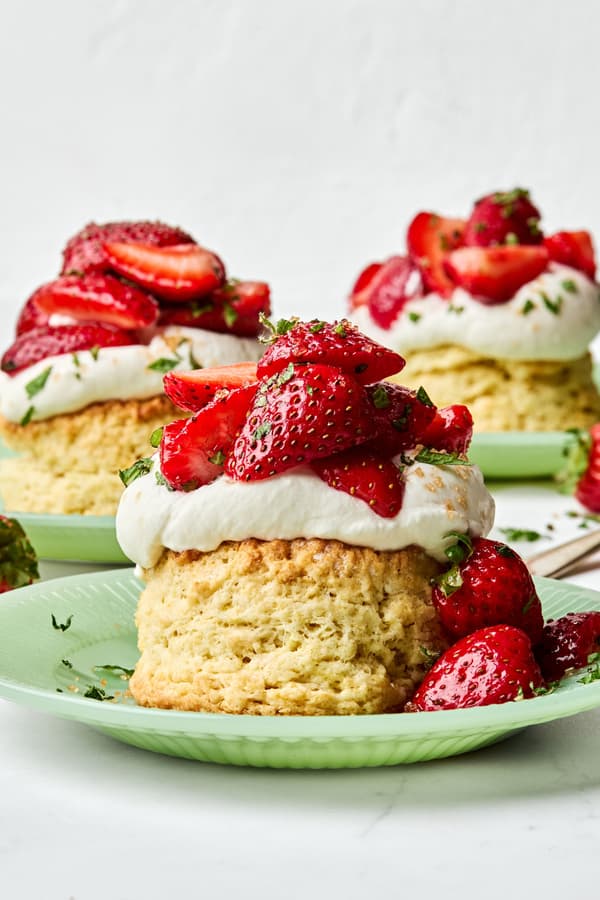Homemade strawberry shortcake topped with fresh sliced strawberries and fluffy whipped cream, served on a flaky biscuit