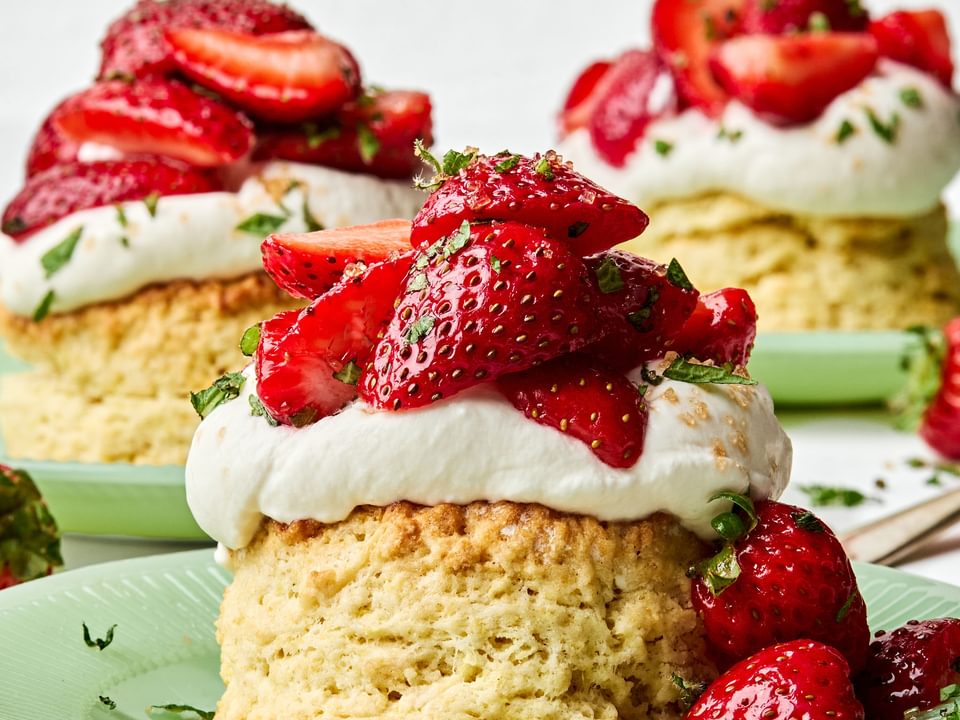 Homemade strawberry shortcake topped with fresh sliced strawberries and fluffy whipped cream, served on a flaky biscuit
