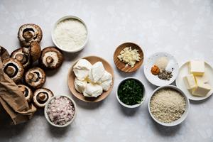 mushrooms, butter, cream cheese, parmesan, spices, parsley and panko breadcrumbs in prep bowls to make stuffed mushrooms