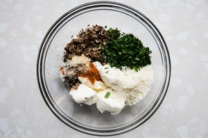 cooked shallots, garlic and mushroom stems, in a mixing bowl with cream cheese, Parmesan cheese and spices