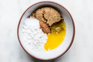 melted butter, pecans, salt, brown sugar, flour and cinnamon in a mixing bowl on the counter
