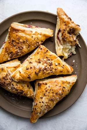 Homemade Turkey Hand Pies filled with mashed potatoes, cranberry sauce on a serving plate