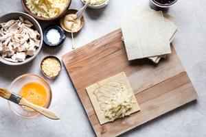 homemade turkey hand pies being assembled on a cutting board surrounded by all the ingredients