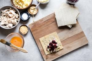 homemade turkey hand pies being filled with mashed potatoes, turkey and cranberry sauce