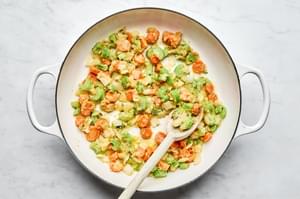 onion, celery, and carrots being cooked in butter in a skillet