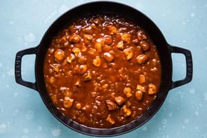 cooked vegetables in a skillet with taco seasoning, green chilies and enchilada sauce for vegetarian enchilada skillet