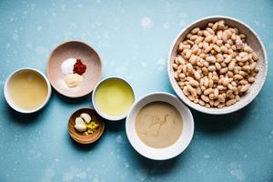 White beans in a bowl, tahini in a bowl, lemon juice, garlic, lemon zest, garlic, paprika, and olive oil