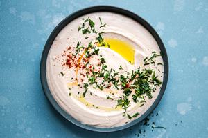 homemade White Bean Hummus in a bowl with paprika, olive oil and parsley