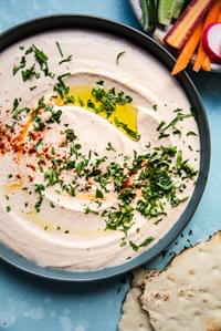 homemade White Bean Hummus in a bowl with paprika, olive oil and parsley