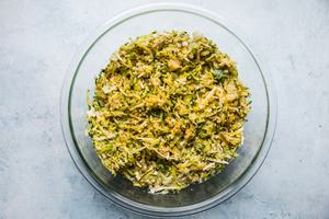 panko, eggs, zucchini, cheese and spices mixed together in a bowl for a zucchini bake